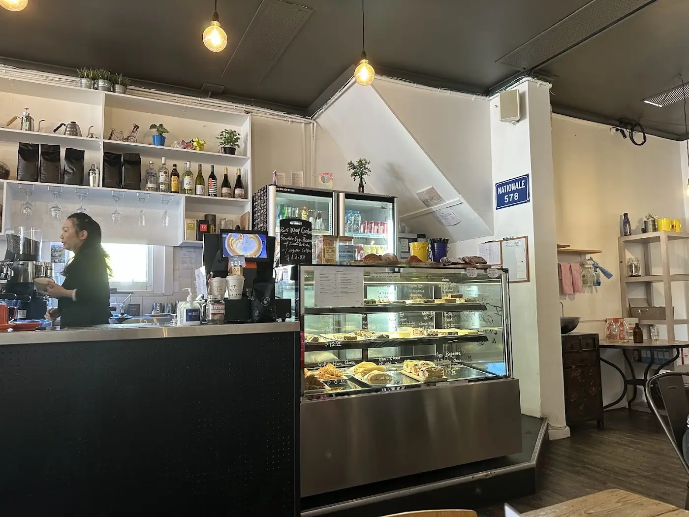 The dining room at Thread Cafe with artworks on the wall and pendant lights